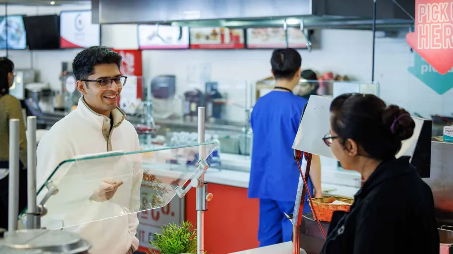Student and service worker at food court at 51 Dockside Dr., Waterfront Campus