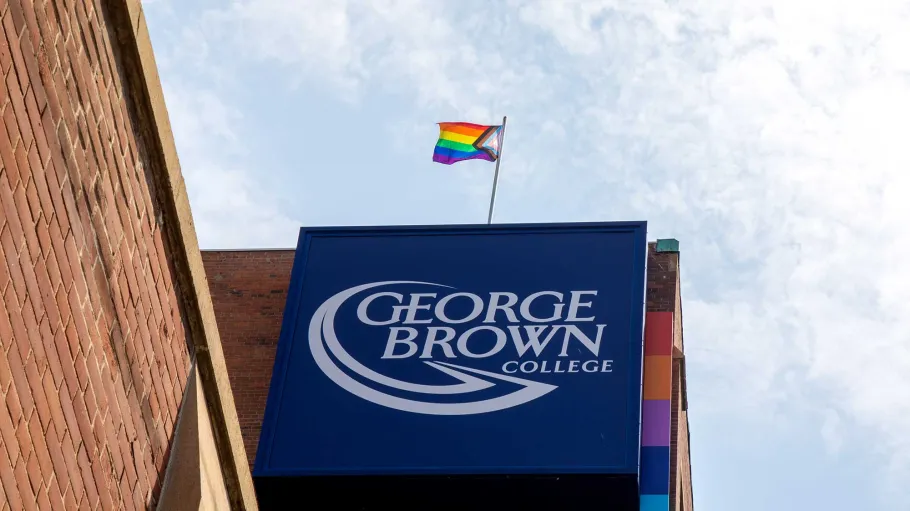 Pride Flag flying over George Brown Polytechnic sign at 200 King Street East.