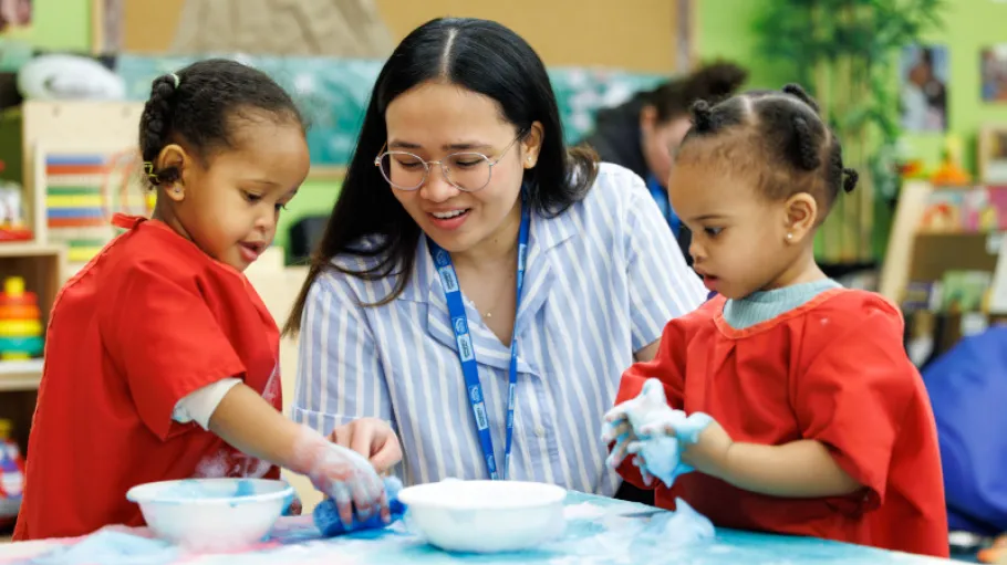 ECE student in with two toddlers making art