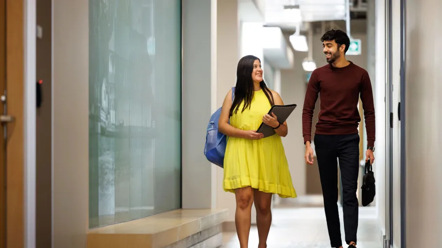 Two students walking down a hallway