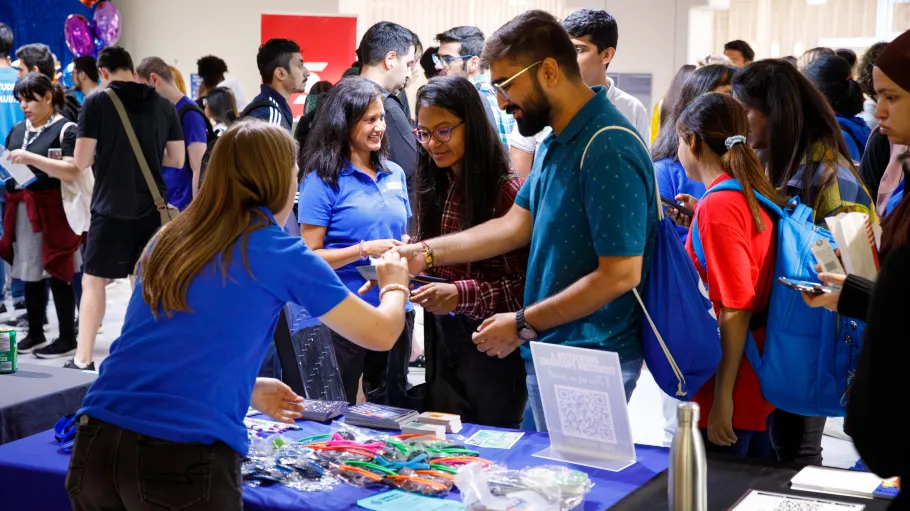 Students interact with volunteers at a booth to learn about services at a Casa Loma Campus Day.