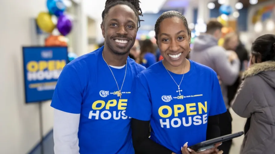 Two students smiling wearing Open House t-shirts.