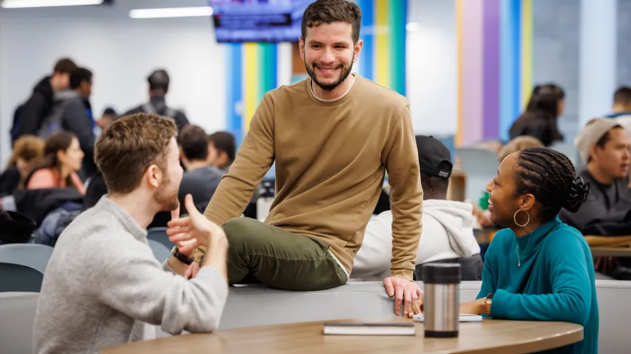 Three students chatting at a table