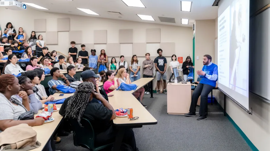 Students sit in a classroom for a program orientation, listening to the Dean.