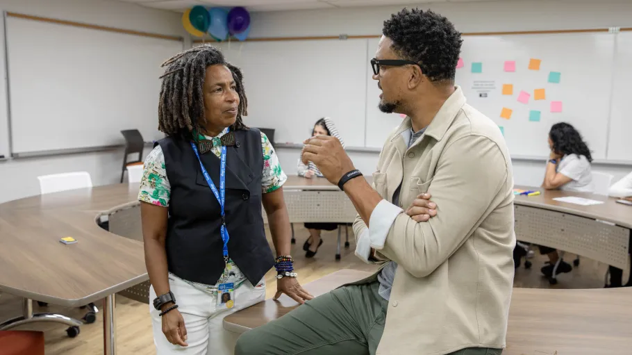 An employee and visitor chat to each other in the Gathering Space. 