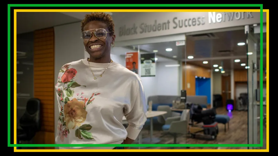 A woman smiles in front of the Black Studnet Success Network entrance