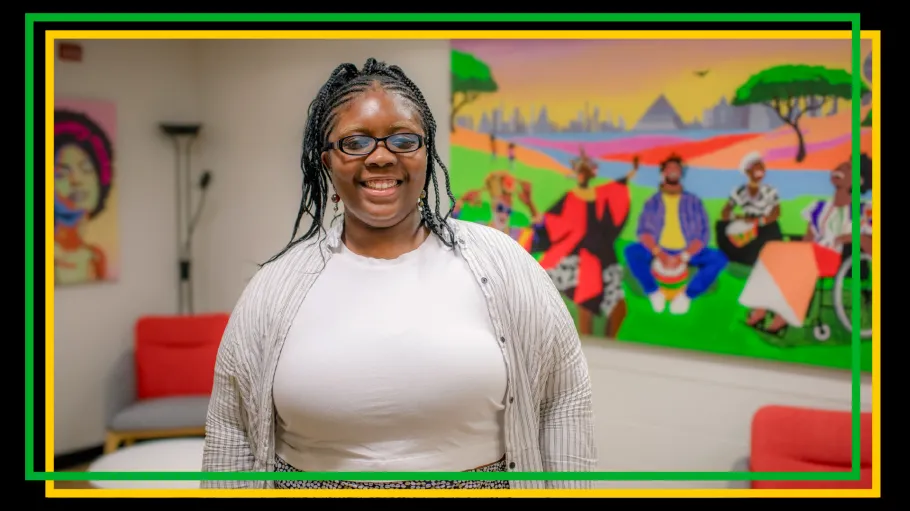 A woman stands in front of colourful paintings and furniture in a brightly lit space