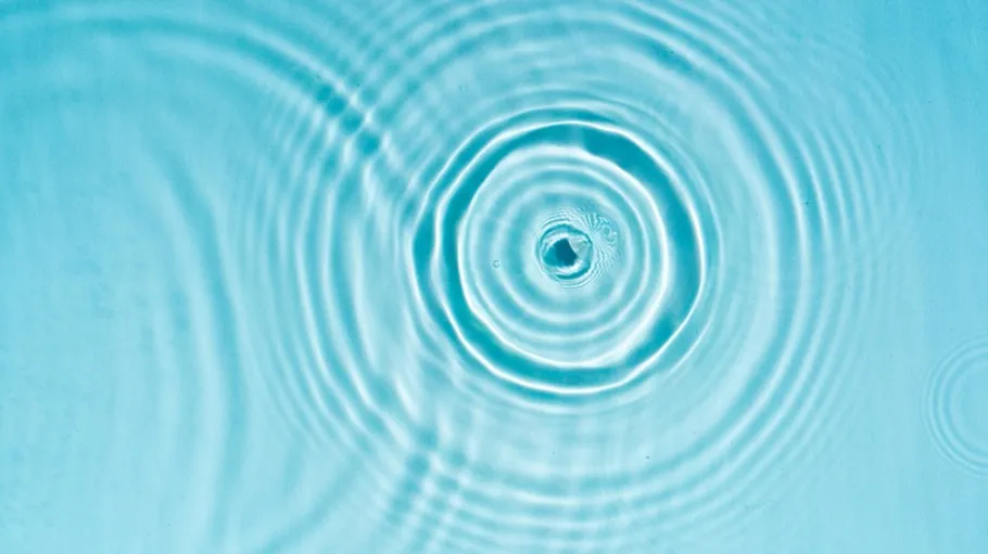 Transparent blue clear water surface texture with ripples Circles and waves on blue water in sunlight Cosmetic moisturizer micellar toner emulsion