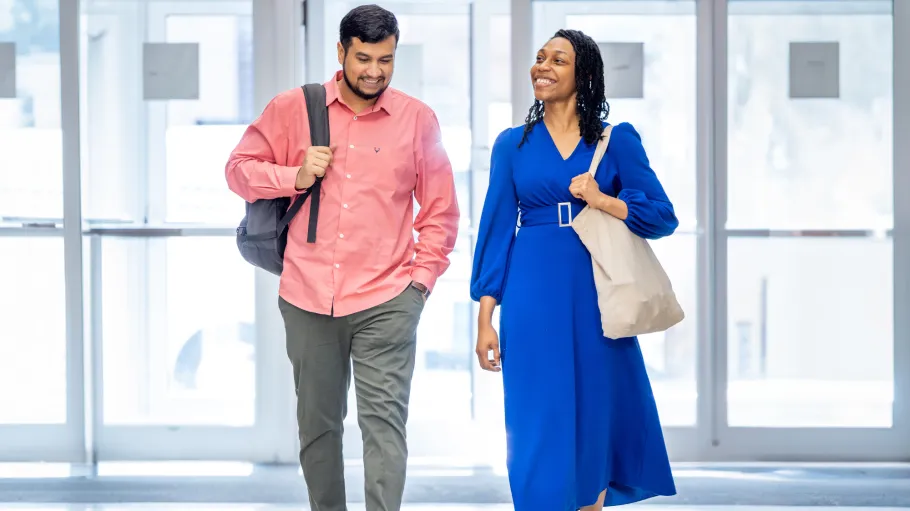 Two students walking in a brightly lit space
