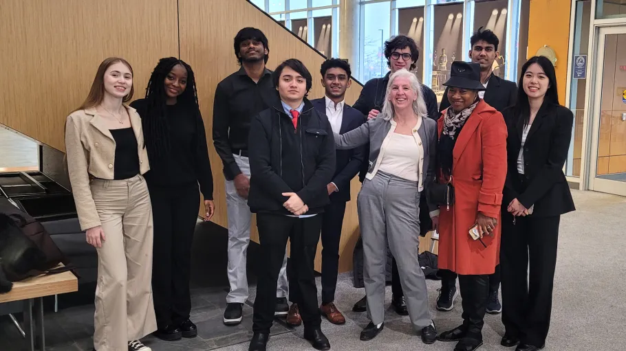 A group of GBC accounting case competition students and faculty pose as a group in a brightly lit space