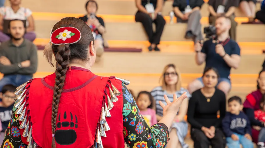 A women from the Mississaugas of the Credit First Nation tells a story about her traditional clothing and dance to the child care child