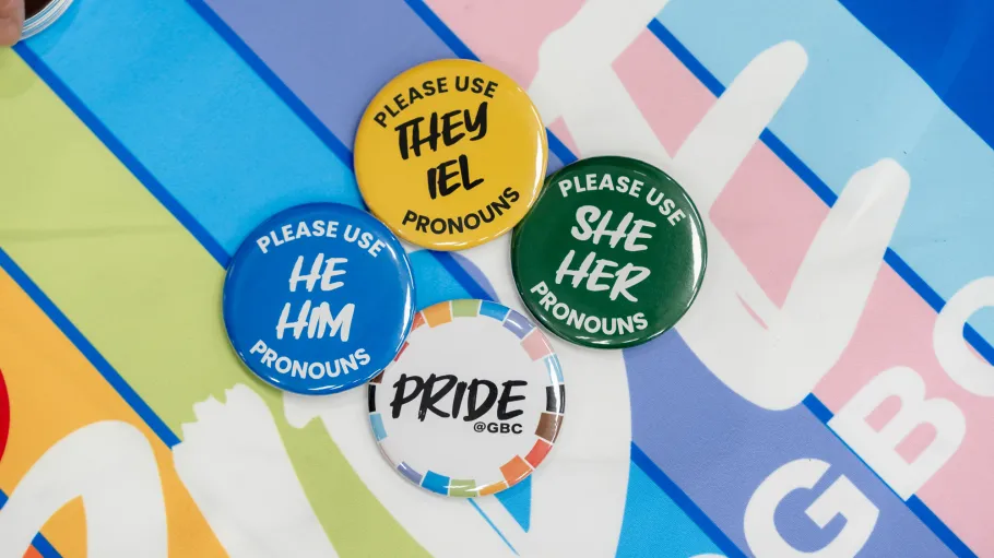 Colourful pronoun buttons are laid against a colourful background