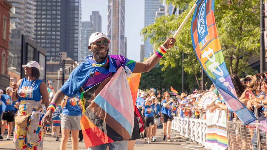 Pride Parade participant waving GBC Pride flag