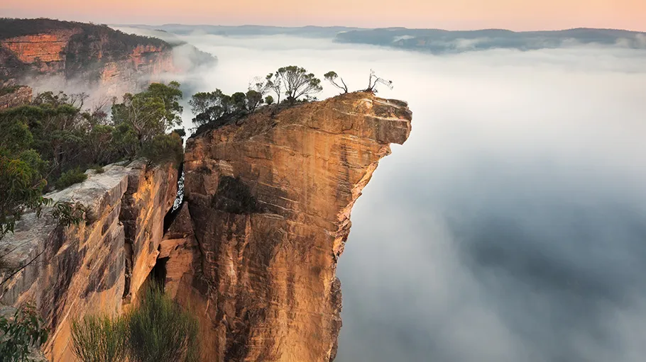 the famous Hanging Rock in Australia, as seen from above the clouds and perched on the of a very tall cliff