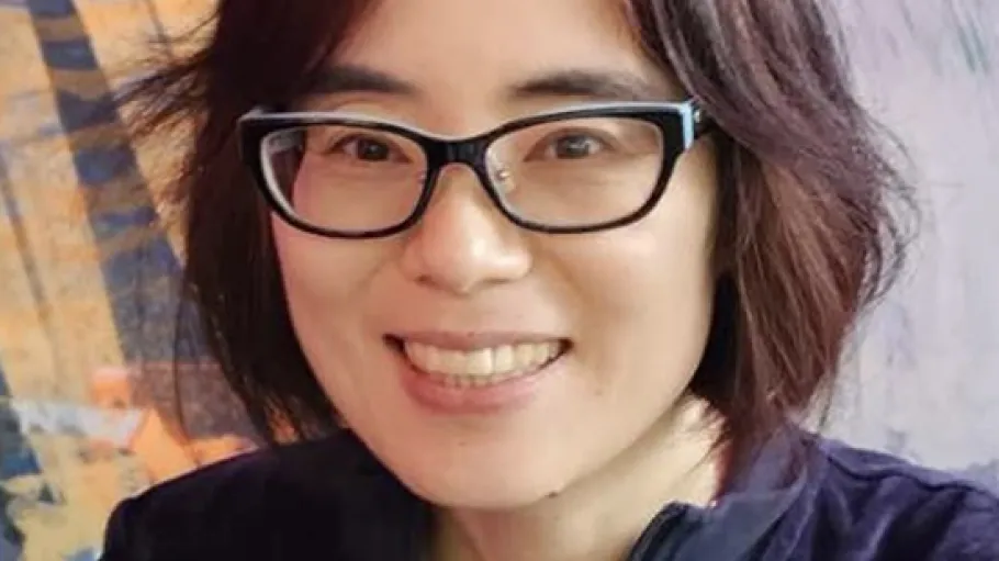 A woman wearing glasses and smiling