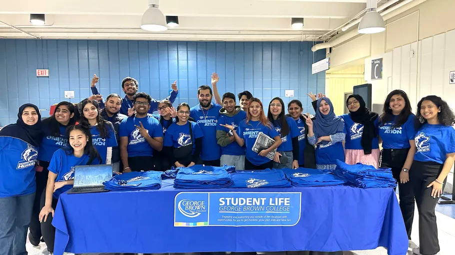Student volunteers stand around a desk to pose for the camera.