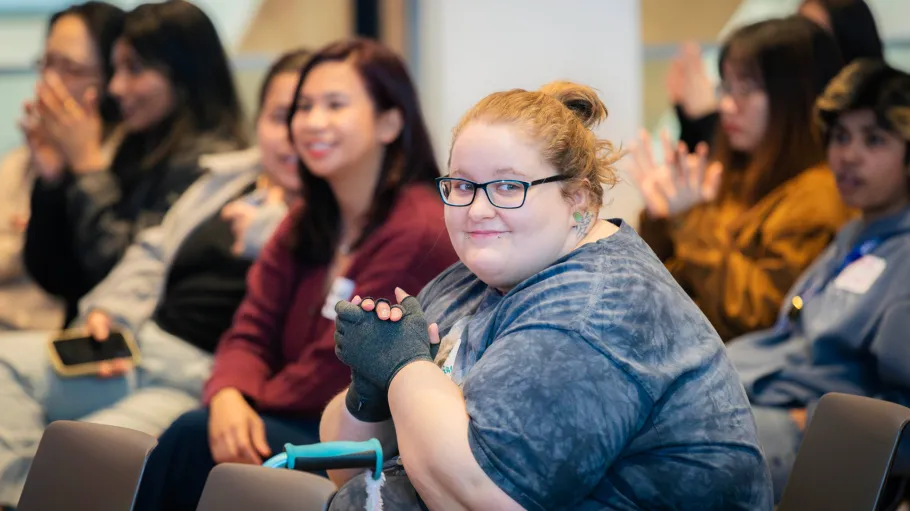 Guests at the Mental Health Conference smile while seated in the audience