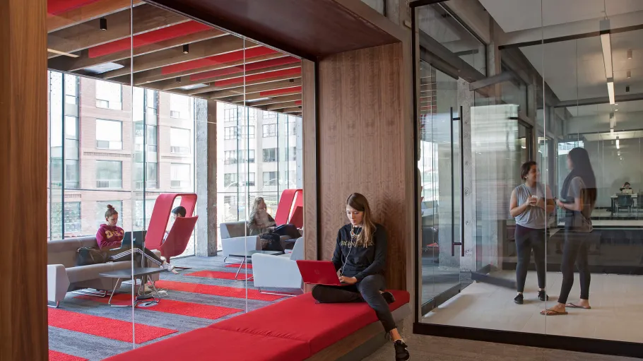 Parkside residence interior view of the student lounge with wood surfaces and red seating