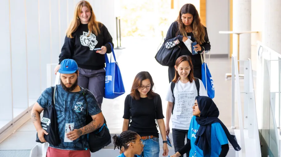 A tour guide leads a group of students down stairs.