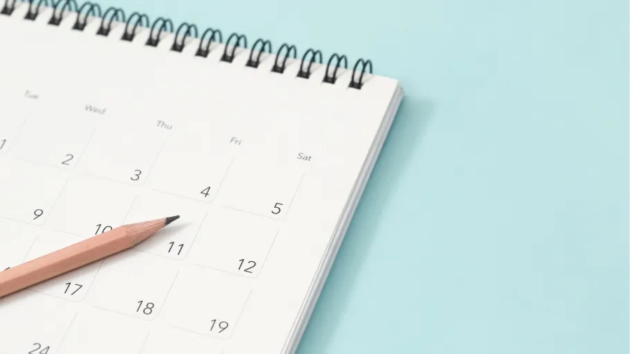 a pencil and a calendar on light blue background