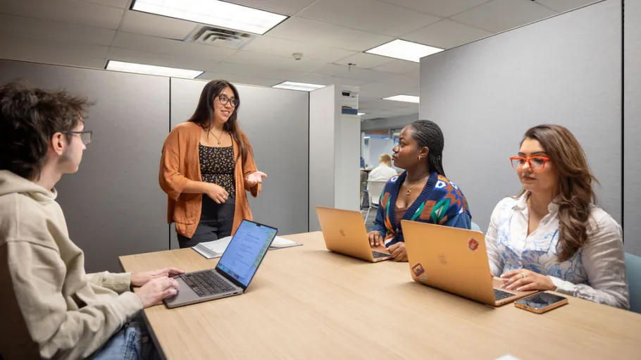 A George Brown Polytechnic staff member speaks with students using laptops during a group session in the Assessment Centre.