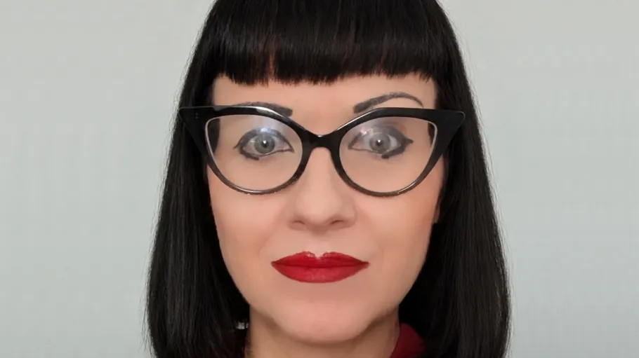 Image of a woman with glasses, black hair, and red lipstick.