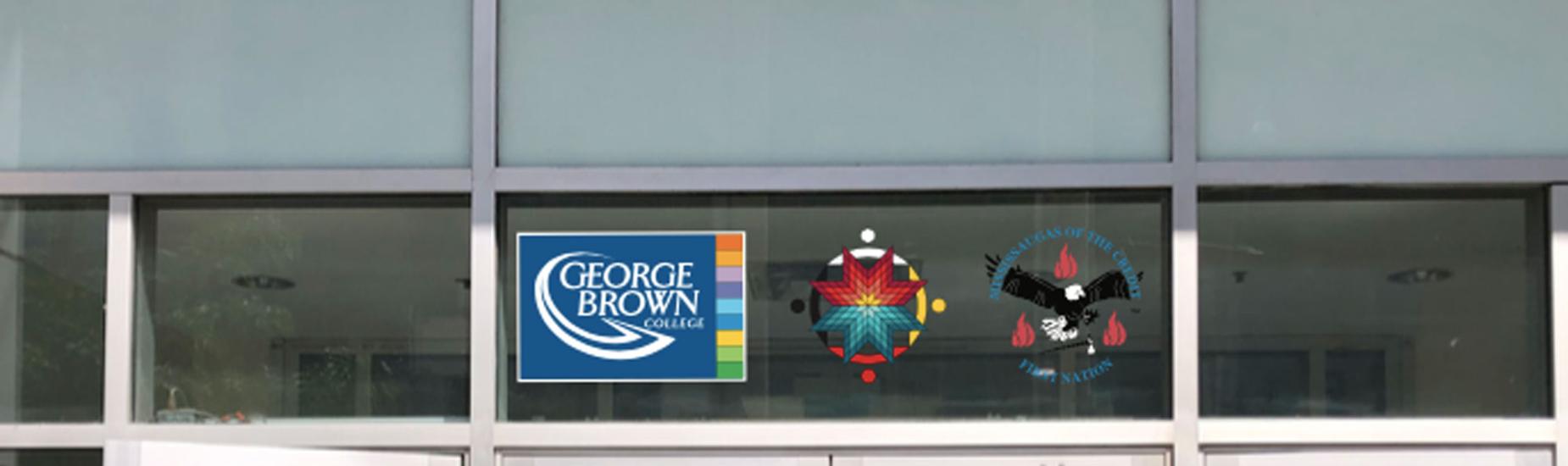 The crest of the Mississaugas of the Credit First Nation, along with the medallion of our Indigenous Initiatives team, proudly displayed next to the George Brown College logo above a campus doorway.