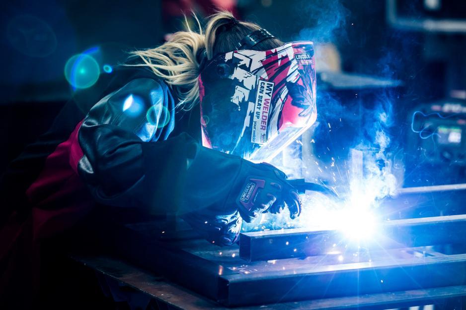 Student welding an object in the lab. 