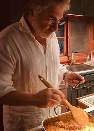 Gary Lengyel holding a wooden spoon, stirring a pot