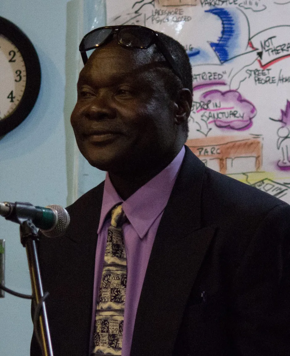 George Brown College professor Peter Madaka in front of a microphone.