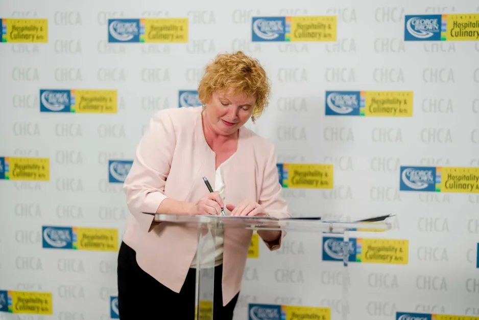 Lorraine Trotter signing the foundation cheque
