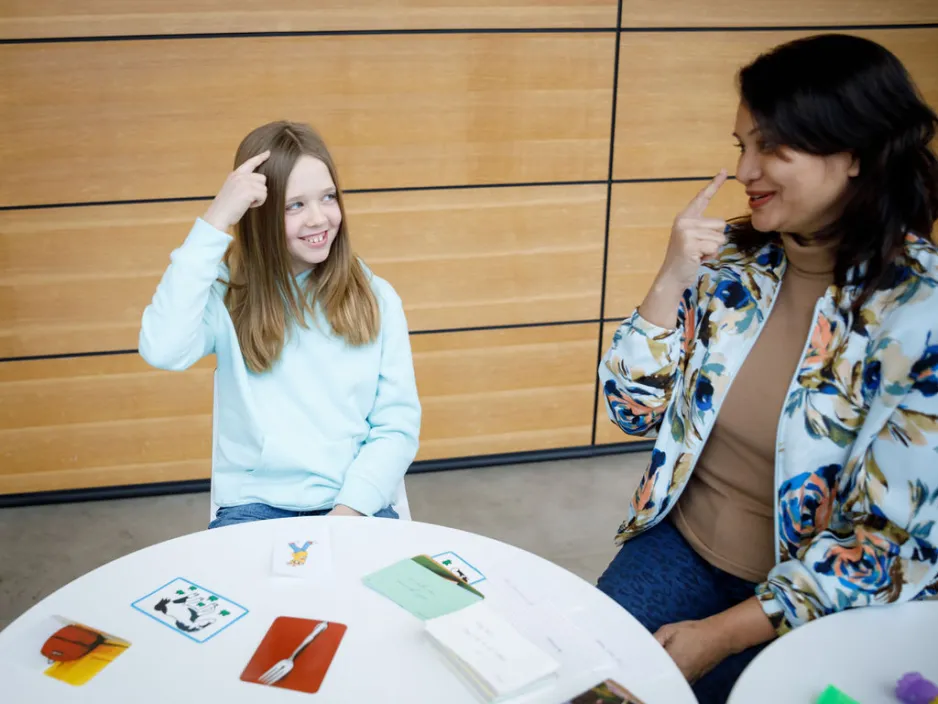 a smiling instructor sits with a girl