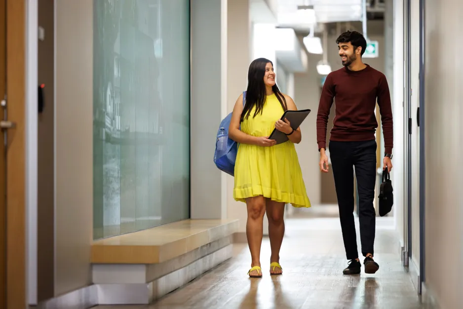 Two students walking down a hallway