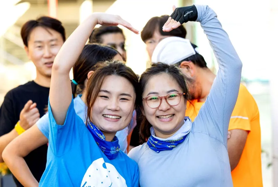 2 employees making a heart with their arms