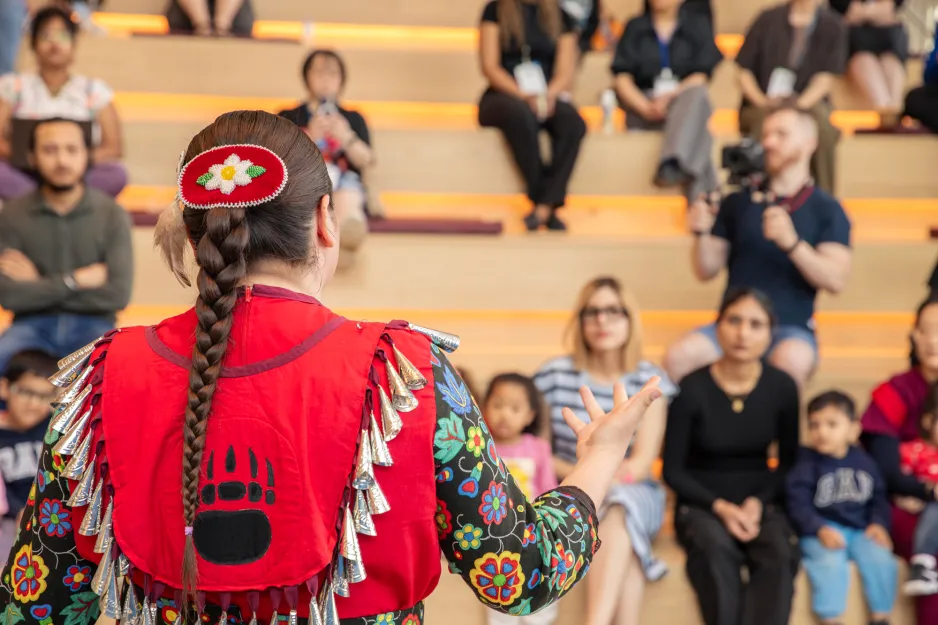 A women from the Mississaugas of the Credit First Nation tells a story about her traditional clothing and dance to the child care child