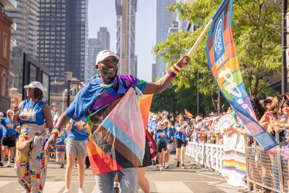 Pride Parade participant waving GBC Pride flag