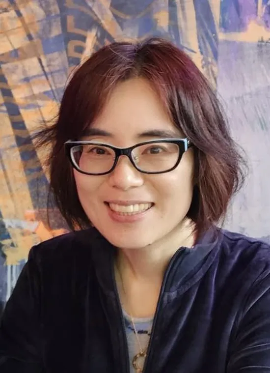 A woman wearing glasses and smiling