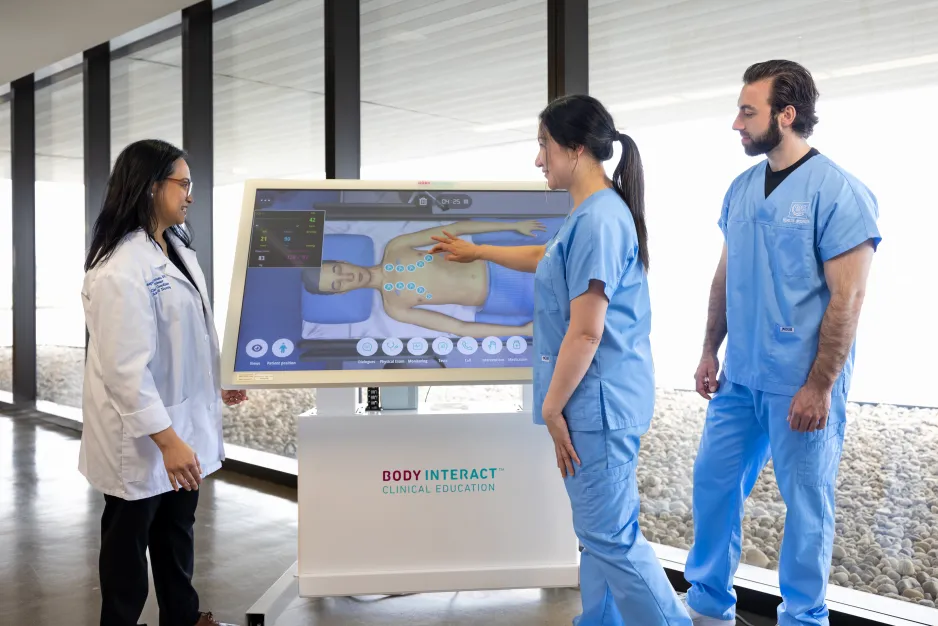 3 nursing students using a virtual patient simulator.