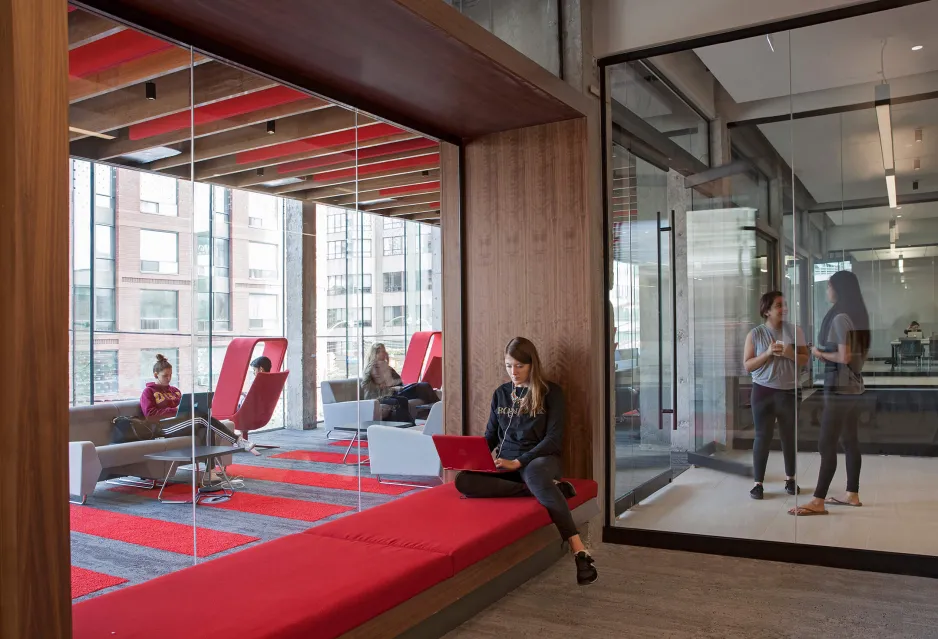 Parkside residence interior view of the student lounge with wood surfaces and red seating