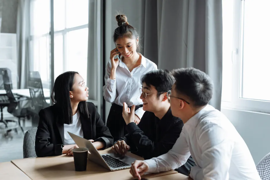 Four people looking at a laptop and having a discussion