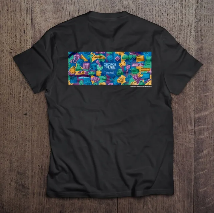 A black tshirt with the 2026 convocation mural printed across the back against a wooden surface.
