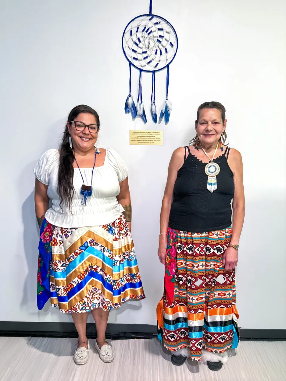 Nathenia and Mary Bonnell stand next to the gifted dream catcher inside the wave clinic.