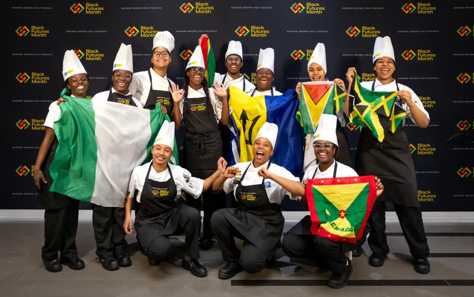 Black Chef School students pose with their flags at the Roots and Recipes culinary event for Black Futures Month.