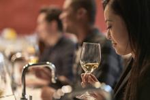 young Asian woman sniffing a glass of wine