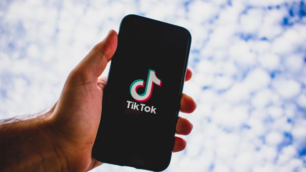 Hand holding phone with TikTok app displayed