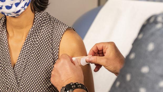 A woman getting a bandage after a vaccination