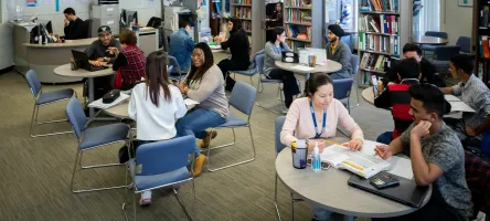 Groups of students studying at small tables
