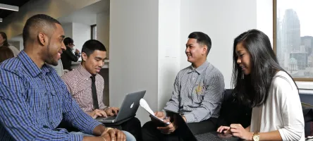 A group of students working together on the business floors.
