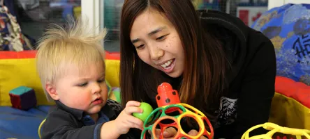 Childcare professional interacting with toddler