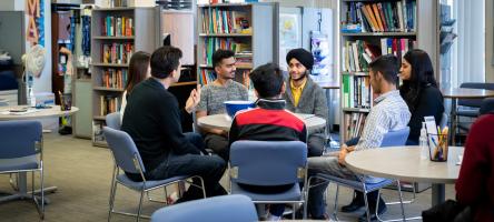 A wide shot of a group of students sitting together with a Tutoring and Learning Centre staff during a workshop session.